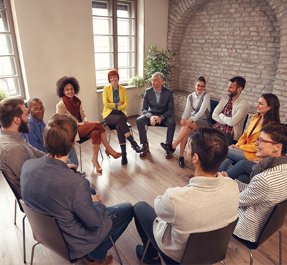 Weiterbildungen für Fachkräfte. Arbeitskreis Integration. Das Bild zeigt eine erwachsene Frau mit drei Kindern an einem Tisch. Die Kinder spielen.