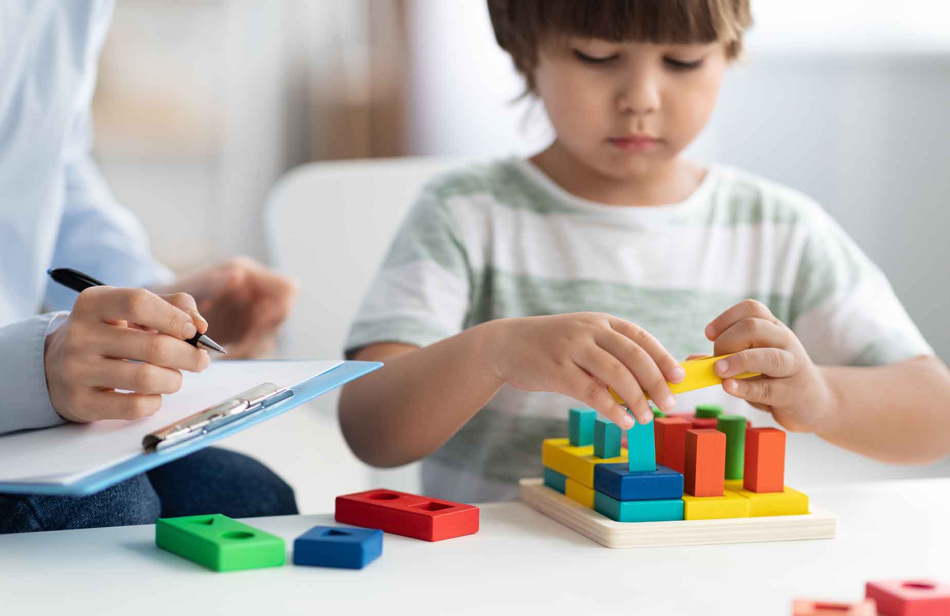 BSL bietet sozialpädagogische Familienhilfe an. Das Bild zeigt erwachsene Frau mit zwei jugendlichen Kindern. Sie sitzen an einem Tisch und machen Hausaufgaben.
