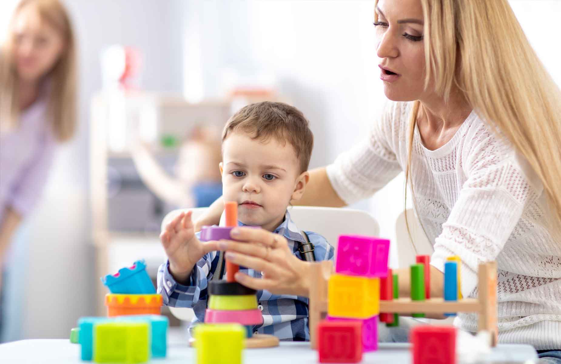 BSL bietet sozialpädagogische Familienhilfe an. Das Bild zeigt erwachsene Frau mit zwei jugendlichen Kindern. Sie sitzen an einem Tisch und machen Hausaufgaben.